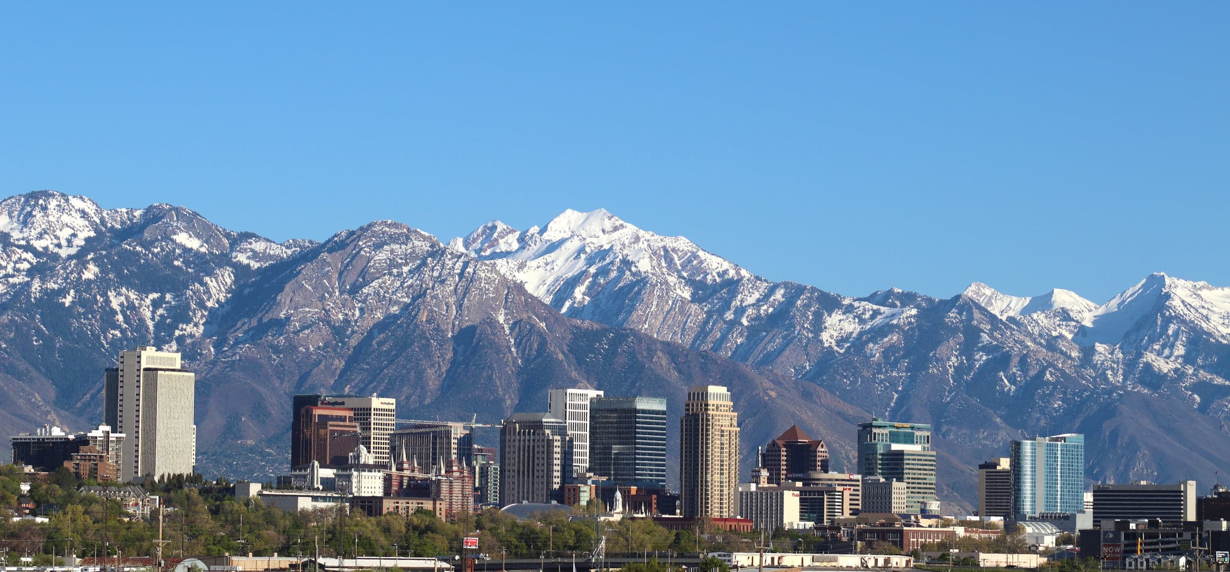 The Salt Lake City skyline with the Wasatch Range rising behind it.